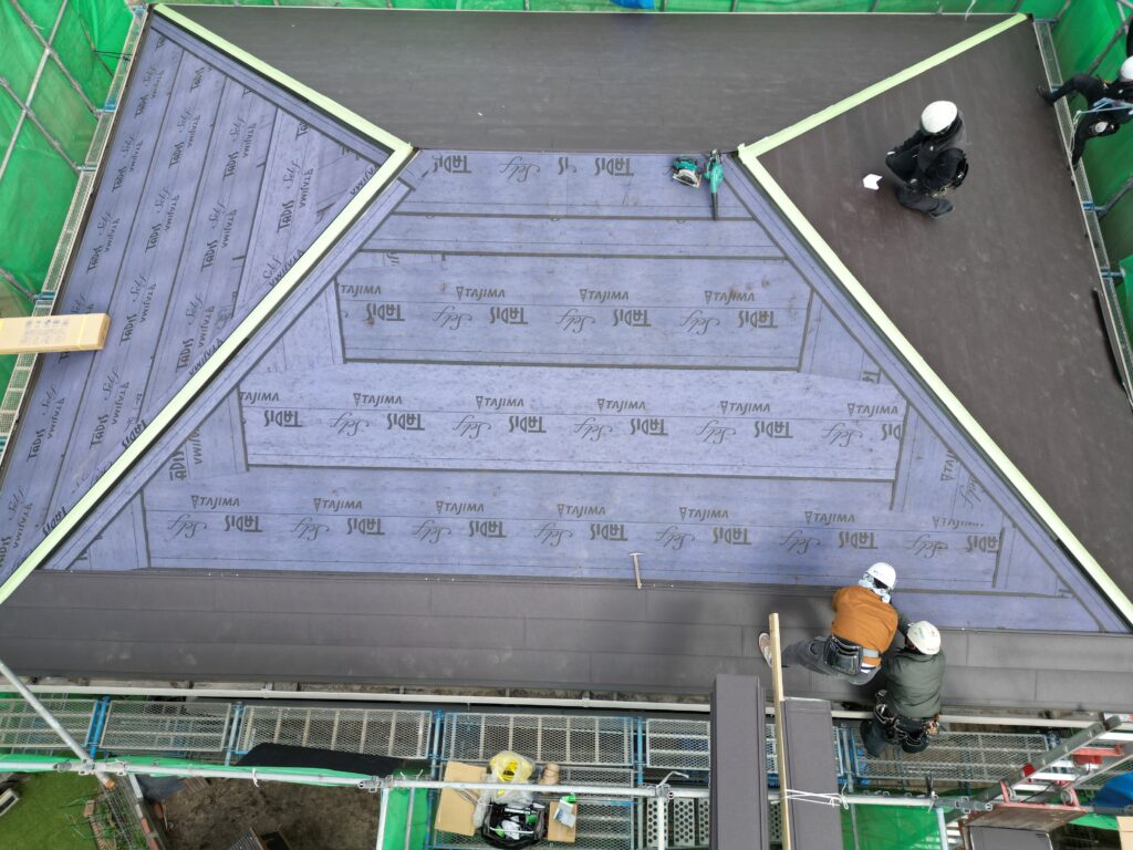 ②新しい屋根材を設置します。下（軒先側）から上へと葺いていきます。<br />ドローンで撮影した作業風景です。