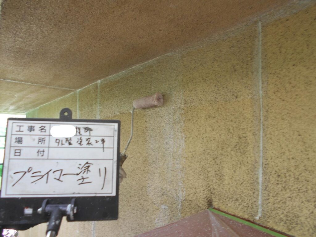①高圧水洗浄で壁の汚れを落とし、養生をして塗装に入ります。<br />
上塗り材をしっかり外壁表面に密着させるためのプライマーを塗ります。